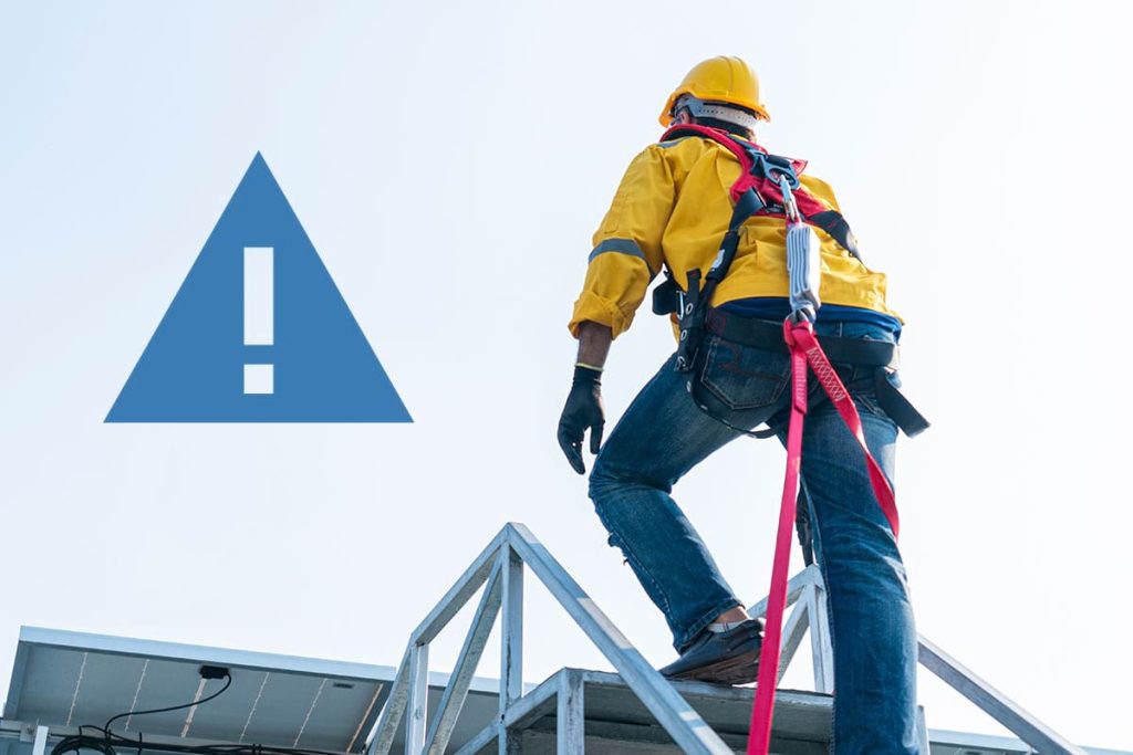 Safety inspector checking equipment on a rooftop, emphasizing the importance of workplace risk assessment.