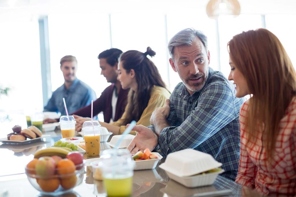 Happy employees in a meeting discussing future health promotion strategies.